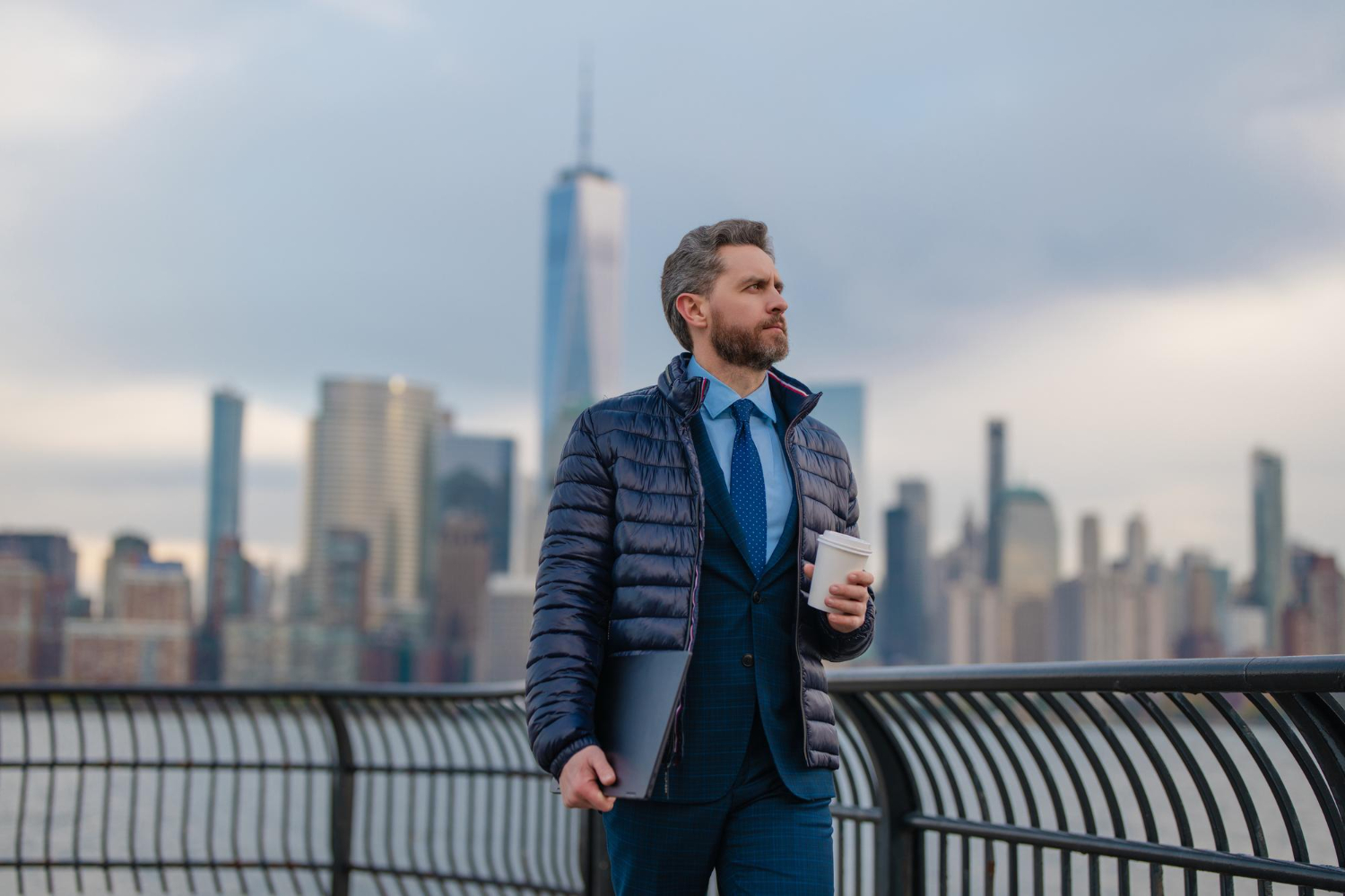 Homem com notebook diante de uma paisagem urbana no exterior